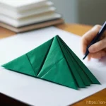 종이공예 워크숍 - **Prompt:** A close-up, high-angle shot focusing on an adult's hands meticulously folding a vibrant ...